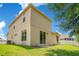 Rear exterior view of a two-story home with neutral paint and access to a green backyard at 212 Citrus Landing Dr, Plant City, FL 33563