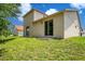 Two-story home exterior showing a sliding glass door leading to a spacious green backyard at 212 Citrus Landing Dr, Plant City, FL 33563