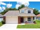 Charming two-story home featuring a two-car garage, brick accents and a well-manicured lawn at 212 Citrus Landing Dr, Plant City, FL 33563