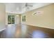 Spacious living room with dark wood floors, ceiling fan, large windows, and sliding glass door at 212 Citrus Landing Dr, Plant City, FL 33563
