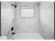 Bathroom featuring new marble-look tile, a black shower head, and a window at 4119 Beacon Square Dr, Holiday, FL 34691