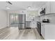Modern kitchen featuring stainless steel appliances, white cabinets, and quartz countertops at 4119 Beacon Square Dr, Holiday, FL 34691