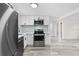 Stylish kitchen featuring stainless steel appliances, white cabinetry, and modern flooring at 4119 Beacon Square Dr, Holiday, FL 34691