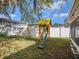 Backyard with a wooden playset, slide, and swing, set against a backdrop of lush greenery at 4601 Copper Ln, Plant City, FL 33566