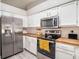 Modern kitchen featuring white cabinets, butcher block counters, and stainless steel appliances at 4601 Copper Ln, Plant City, FL 33566