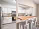 Well-lit kitchen with white cabinets, wooden countertops, stainless steel appliances, and a bar area with seating at 4601 Copper Ln, Plant City, FL 33566