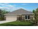 Charming single-story home featuring a two-car garage, well-manicured lawn, and simple landscaping at 6353 Scarlet Amethyst St, Land O Lakes, FL 34638