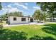 Backyard view of a single-story home showcasing gravel area, lush lawn, and mature trees at 2239 Worrington St, Sarasota, FL 34231