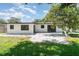 Backyard view of a single-story home featuring a gravel area, lawn, and a tree at 2239 Worrington St, Sarasota, FL 34231