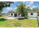 Backyard featuring a single-story home, gravel area, lush green grass, partial fence and mature tree at 2239 Worrington St, Sarasota, FL 34231