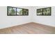 Bright bedroom featuring hardwood floors, white walls, and two windows at 2239 Worrington St, Sarasota, FL 34231