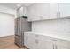 This kitchen features white cabinets, quartz countertops, stainless steel refrigerator, and subway tile backsplash at 2239 Worrington St, Sarasota, FL 34231