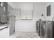 Dedicated laundry area with washer, dryer, water heater, and storage cabinet at 2239 Worrington St, Sarasota, FL 34231