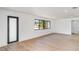 Bright living room featuring light wood floors, and a modern black front door at 2239 Worrington St, Sarasota, FL 34231