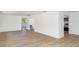Open-concept living room features light wood floors and neutral walls and flows into kitchen at 2239 Worrington St, Sarasota, FL 34231