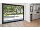View of the backyard through the sliding glass door, with kitchen view on the right, and hardwood floors at 2239 Worrington St, Sarasota, FL 34231