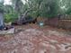 Large backyard featuring a wooded fence line, mature shade tree, and equipment at 3607 Johnson Ct, Palm Harbor, FL 34684