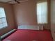 Bedroom with red carpet, a ceiling fan, and natural light from two windows at 3607 Johnson Ct, Palm Harbor, FL 34684