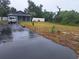 Exterior view of home with driveway, lush lawn, fresh white fencing and mature trees at 3607 Johnson Ct, Palm Harbor, FL 34684