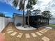 Backyard with pea gravel hardscape, white fence and screened in porch at 9153 86Th Ave, Seminole, FL 33777