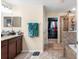 Bathroom featuring double vanity sinks, granite counters, a walk-in closet, and a walk-in shower at 14095 Tropical Kingbird Way, Riverview, FL 33579