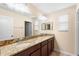 Bathroom featuring dual sinks, granite countertops, and dark wood cabinets at 14095 Tropical Kingbird Way, Riverview, FL 33579
