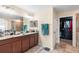 Bathroom featuring double vanity sinks, granite counters, a walk-in closet, and a walk-in shower at 14095 Tropical Kingbird Way, Riverview, FL 33579