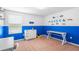 A bedroom is brightly painted with blue, and decorated with cars, complete with desk and dresser at 14095 Tropical Kingbird Way, Riverview, FL 33579