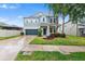 Two-story home featuring a well-manicured lawn, two-car garage, and charming front porch at 14095 Tropical Kingbird Way, Riverview, FL 33579