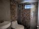 Modern bathroom features a tiled shower with glass doors, stone-look accent wall, and white toilet and sink at 155 Summerset Dr, Punta Gorda, FL 33982