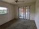 Bedroom with a window, sliding glass door to patio, ceiling fan, and carpet at 155 Summerset Dr, Punta Gorda, FL 33982