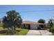 A single-Gathering home featuring a tan exterior, attached garage, and a lush front yard with mature palm trees at 155 Summerset Dr, Punta Gorda, FL 33982