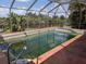 Screened-in pool with an orange deck overlooking a tranquil water view, perfect for outdoor relaxation at 155 Summerset Dr, Punta Gorda, FL 33982