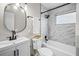 Bathroom features modern vanity, oval mirror, and tiled shower and tub combination at 5629 36Th N Ave, St Petersburg, FL 33710