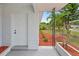 Covered front porch featuring a white door, brick columns, and a beautifully landscaped garden at 5629 36Th N Ave, St Petersburg, FL 33710
