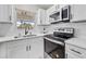 Modern kitchen features white cabinets, stainless steel appliances and a window over the sink at 5629 36Th N Ave, St Petersburg, FL 33710