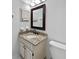 A well-lit bathroom features a granite vanity, a dark framed mirror, and white toilet at 6623 Baybrooks Cir, Temple Terrace, FL 33617