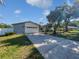 Beautiful single-story home with a well-kept lawn and attached two-car garage on a sunny day at 6623 Baybrooks Cir, Temple Terrace, FL 33617