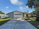 Charming single-story home featuring a well-manicured lawn and attached two-car garage at 6623 Baybrooks Cir, Temple Terrace, FL 33617