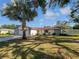 Charming single-story home featuring a spacious front yard, beautiful tree, and an attached two car garage at 6623 Baybrooks Cir, Temple Terrace, FL 33617