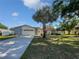Charming single-story home featuring a spacious front yard, beautiful tree, and an attached two car garage at 6623 Baybrooks Cir, Temple Terrace, FL 33617