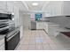 An open kitchen features white cabinets, stainless steel appliances, and granite countertops at 6623 Baybrooks Cir, Temple Terrace, FL 33617