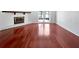 Spacious living room with hardwood floors, white-painted fireplace, and glass doors to the exterior at 6623 Baybrooks Cir, Temple Terrace, FL 33617