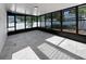 Well-lit sunroom featuring tile floors and large windows, offering views of the surrounding greenery at 6623 Baybrooks Cir, Temple Terrace, FL 33617