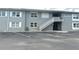 Two-story building featuring gray siding and a staircase leading to the upper-level entrances at 129 104Th Ave # 205, Treasure Island, FL 33706