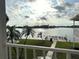 Balcony view overlooking a tranquil waterfront with lush green lawn and palm trees at 129 104Th Ave # 205, Treasure Island, FL 33706