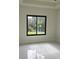 Bright bedroom with white tile flooring and a large window with a view of the greenery outside at 267 Santa Marta St, Port Charlotte, FL 33954