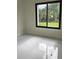 Bright bedroom with white tile flooring and a large window showcasing the outdoor greenery at 267 Santa Marta St, Port Charlotte, FL 33954