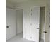 Hallway featuring white doors with black hardware and sleek, white tile flooring at 267 Santa Marta St, Port Charlotte, FL 33954