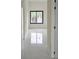 Hallway featuring sleek, white tile flooring and a view of the backyard through a large window at 267 Santa Marta St, Port Charlotte, FL 33954